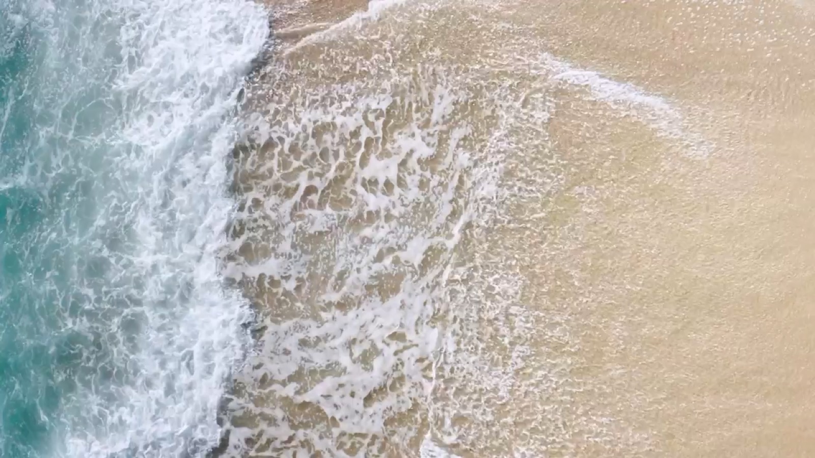 Aerial view of waves meeting the shore